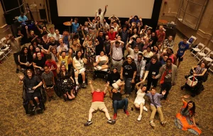 Several people in a carpeted room looking up at the camera